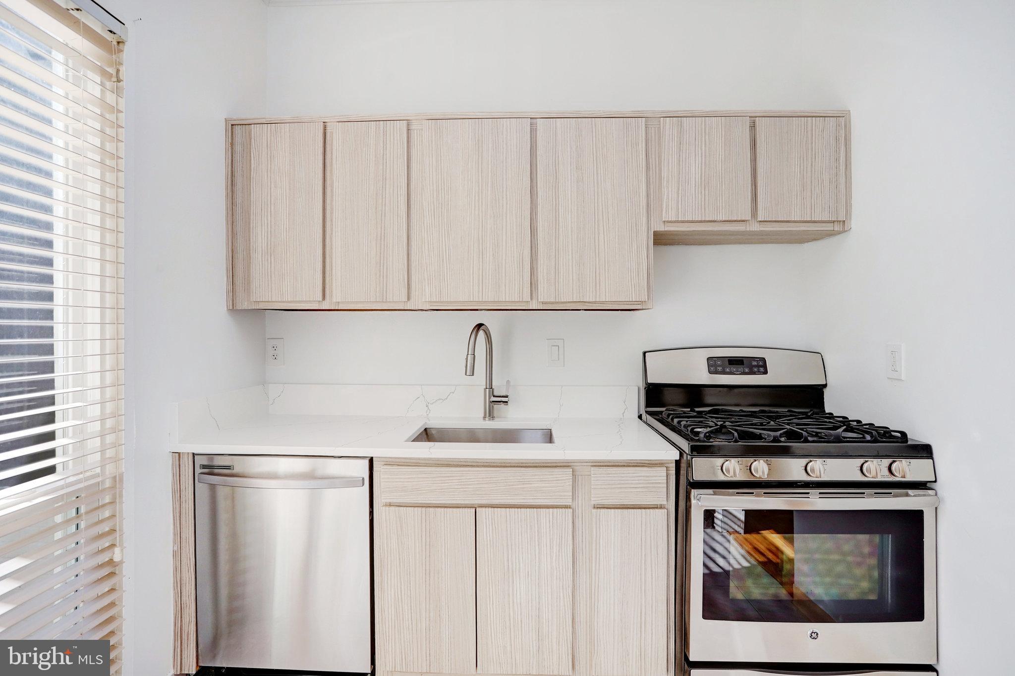 42 G Street Southwest Washington, DC 20024 - Photo 12 of 54 a kitchen with white cabinets and a stove with a sink