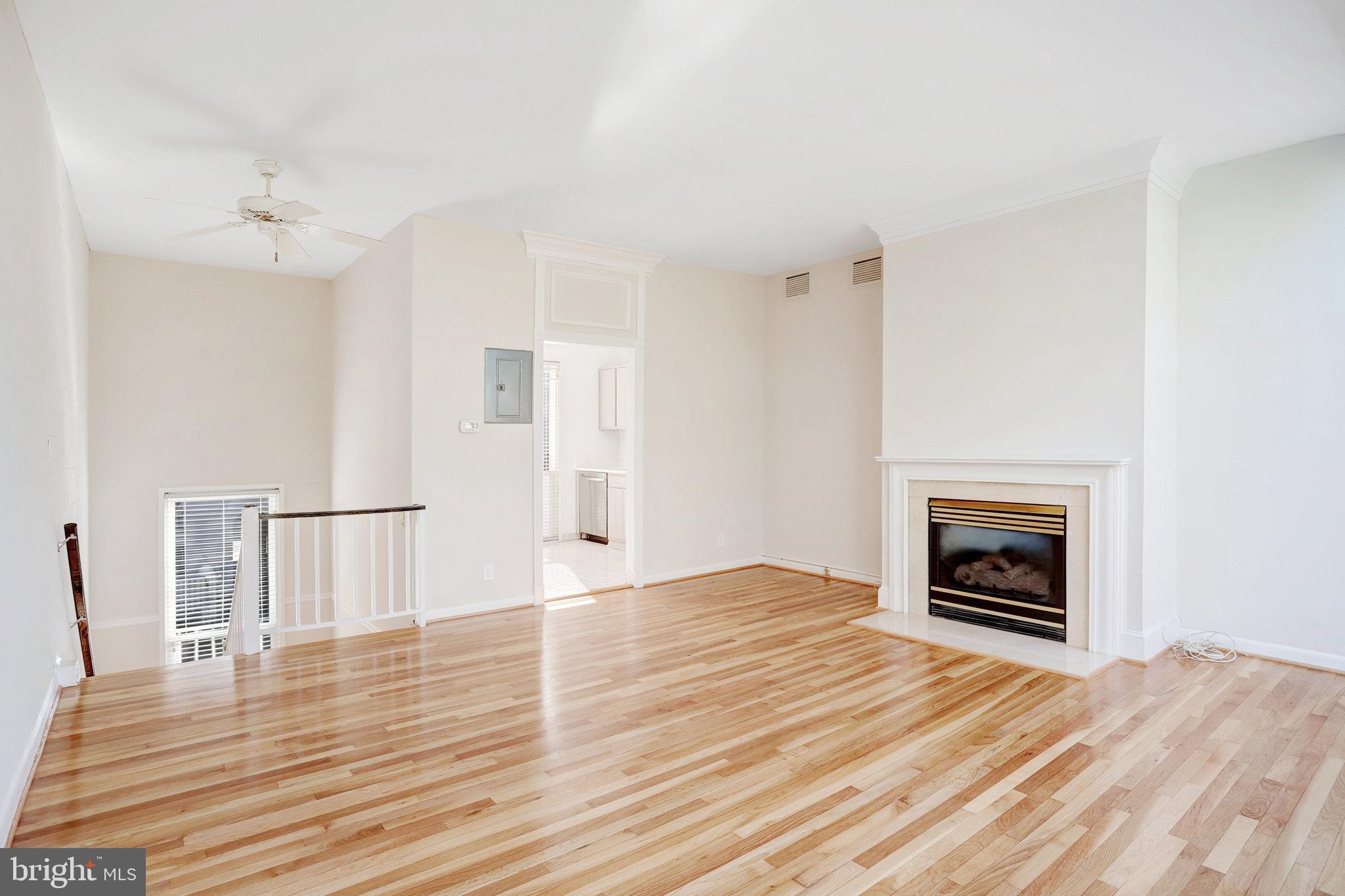 42 G Street Southwest Washington, DC 20024 - Photo 10 of 54 a view of an empty room with wooden floor fireplace and a window