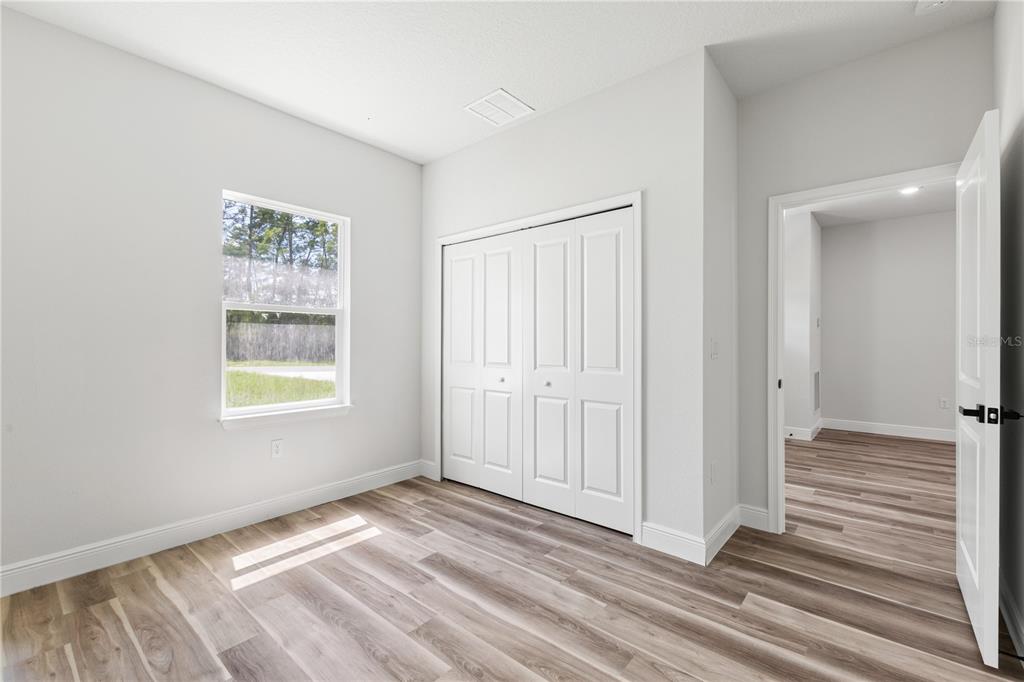 5217 Southwest 165th St Road Ocala, FL 34473 - Photo 21 of 35 a view of an empty room with wooden floor and a window