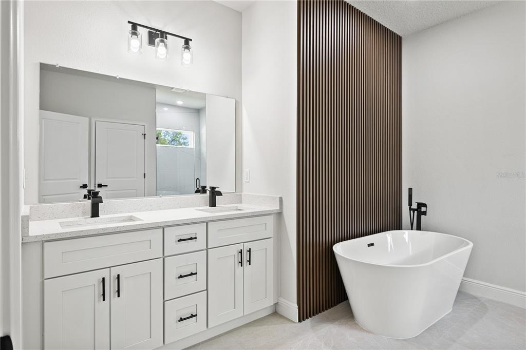 5217 Southwest 165th St Road Ocala, FL 34473 - Photo 22 of 35 a bathroom with a double vanity sink mirror and bathtub