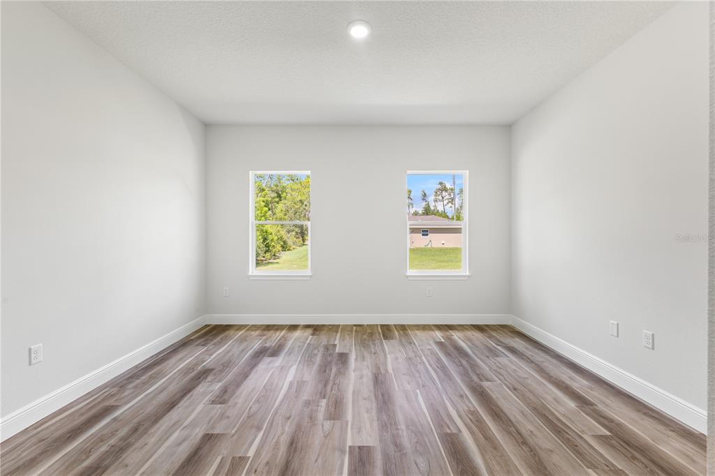 5217 Southwest 165th St Road Ocala, FL 34473 - Photo 26 of 35 an empty room with wooden floor and windows