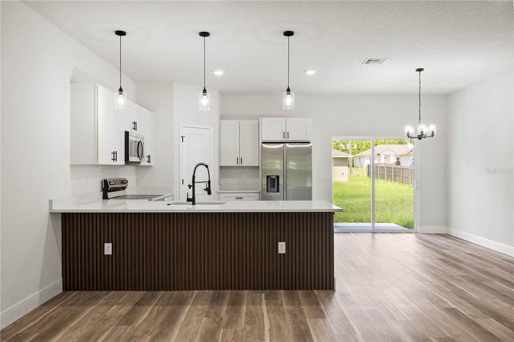 5217 Southwest 165th St Road Ocala, FL 34473 - Photo 4 of 35 a kitchen with kitchen island a sink stainless steel appliances and cabinets