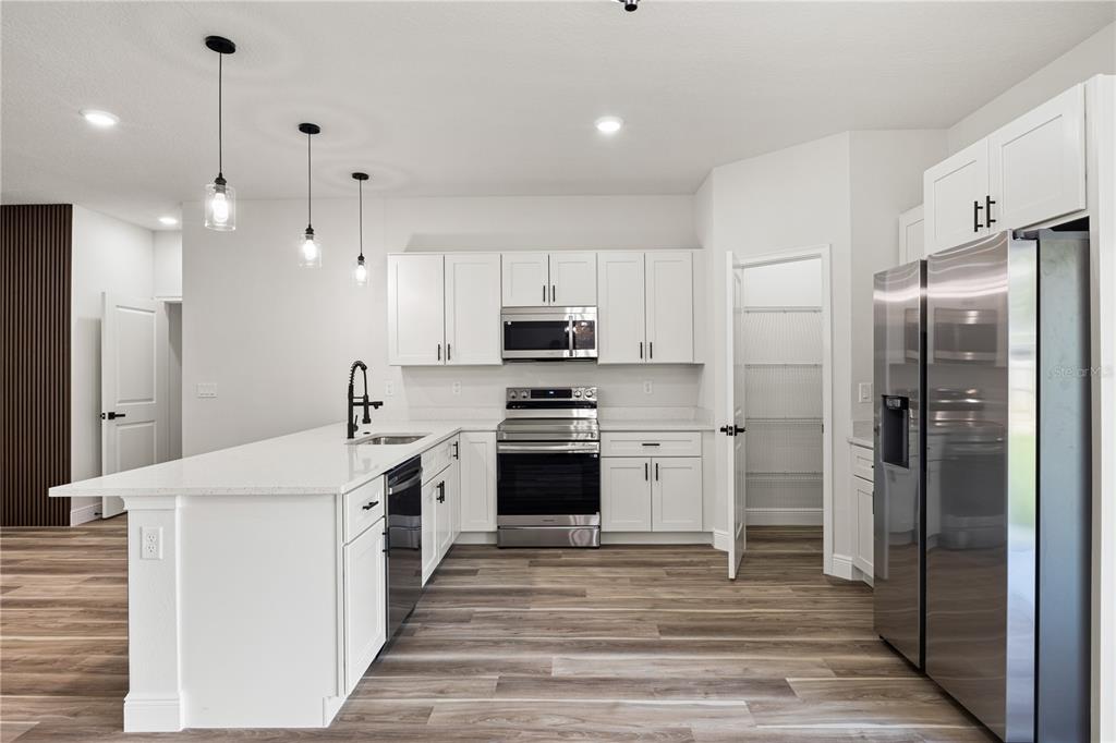 5217 Southwest 165th St Road Ocala, FL 34473 - Photo 6 of 35 a kitchen with stainless steel appliances kitchen island granite countertop a refrigerator and a stove top oven