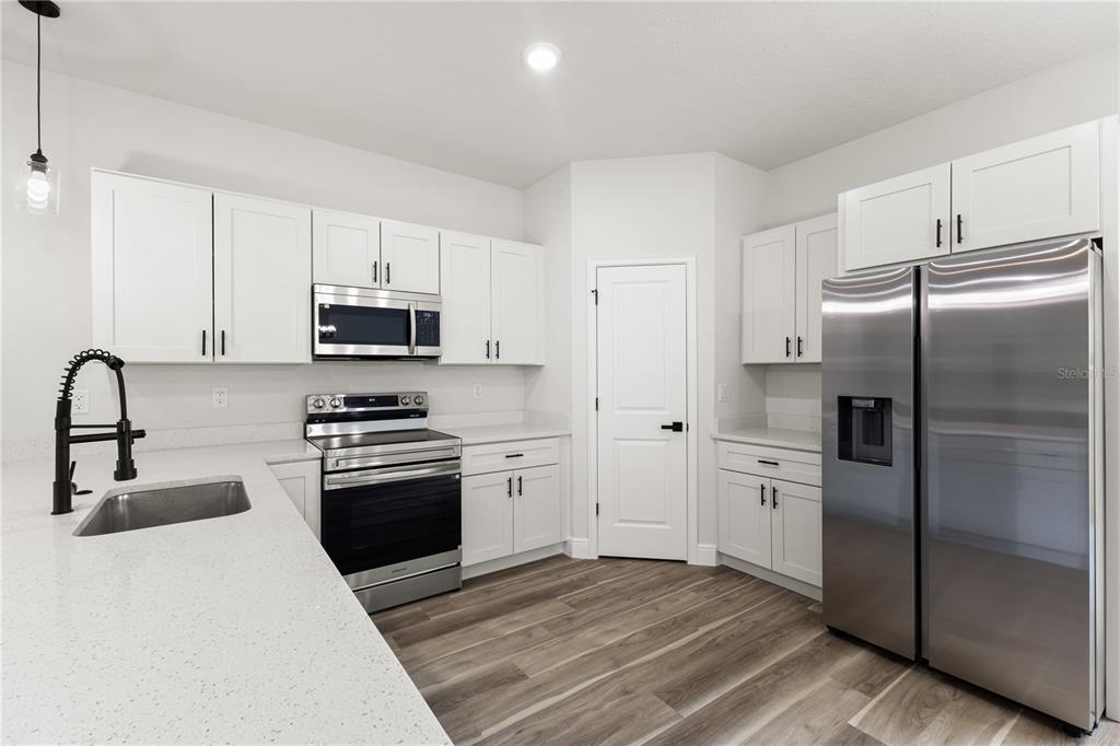 5217 Southwest 165th St Road Ocala, FL 34473 - Photo 7 of 35 a kitchen with stainless steel appliances a refrigerator stove and sink