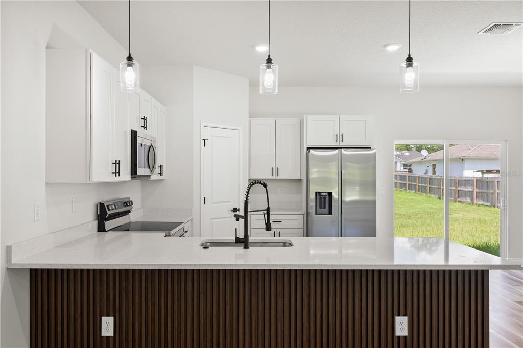 5217 Southwest 165th St Road Ocala, FL 34473 - Photo 8 of 35 a kitchen with kitchen island a sink stainless steel appliances and cabinets