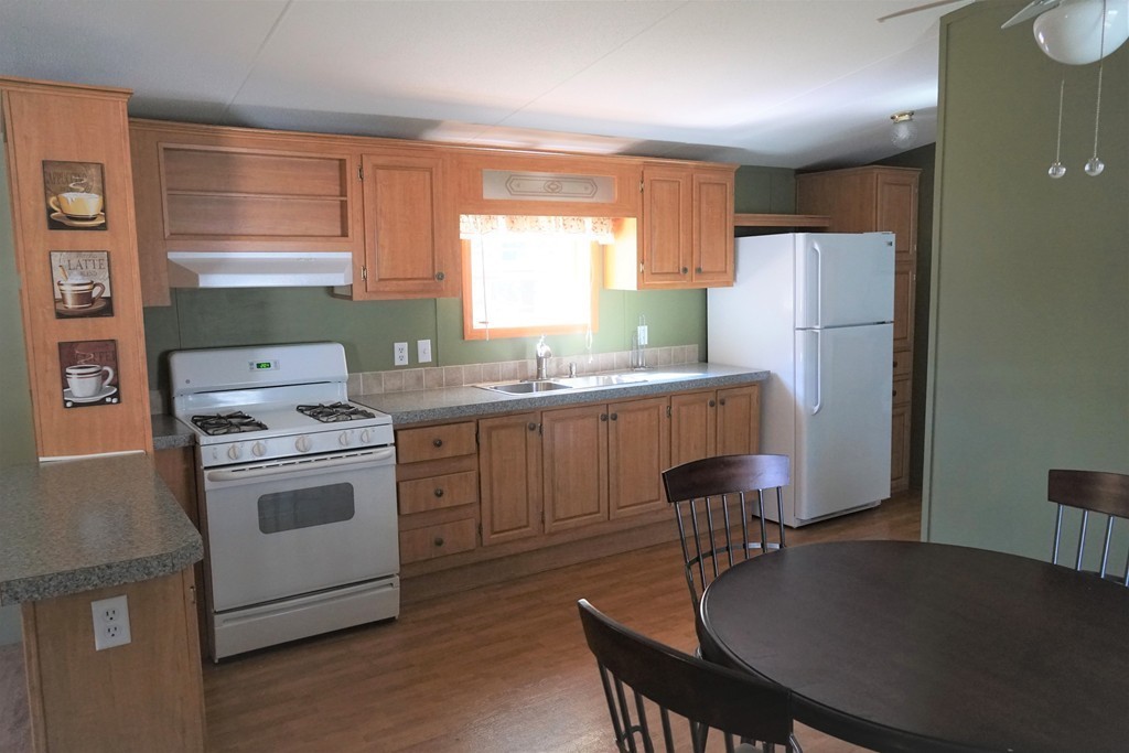 62 Cypress Road Taunton, MA 02780 - Photo 10 of 26 a kitchen with a stove a refrigerator and a dining table