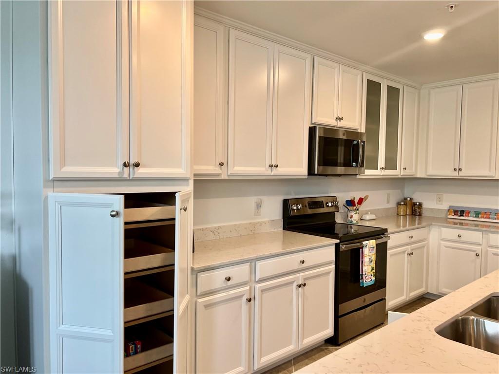 9584 Trevi Court, Unit 5223 Naples, FL 34113 - Photo 12 of 42 a kitchen with stainless steel appliances granite countertop white cabinets and sink