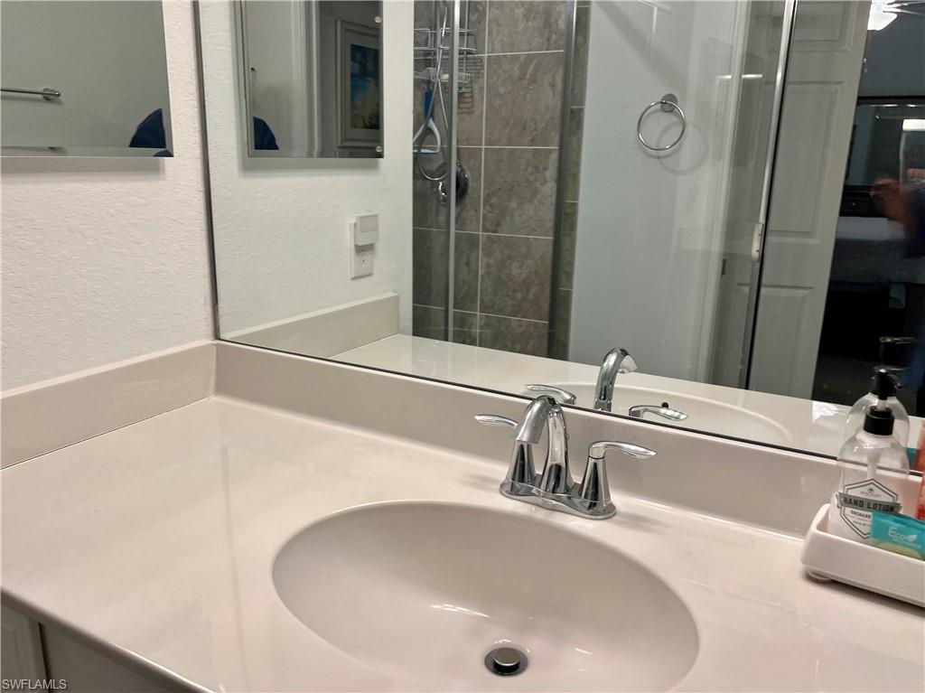 9584 Trevi Court, Unit 5223 Naples, FL 34113 - Photo 31 of 42 a bathroom with a sink and a mirror