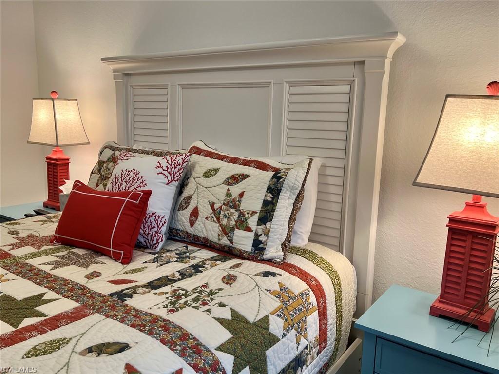 9584 Trevi Court, Unit 5223 Naples, FL 34113 - Photo 34 of 42 a bedroom with a bed and wooden floor