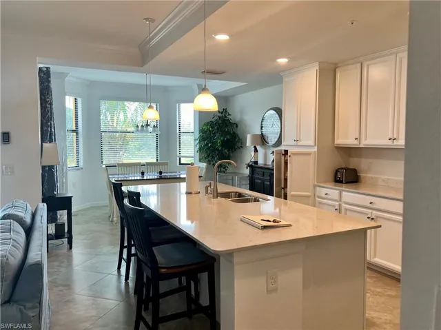 a kitchen with a dining table chairs and white cabinets