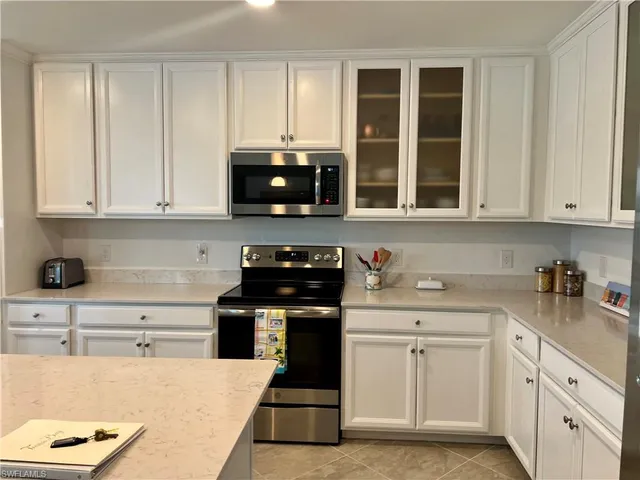 a kitchen with stainless steel appliances white cabinets and a refrigerator