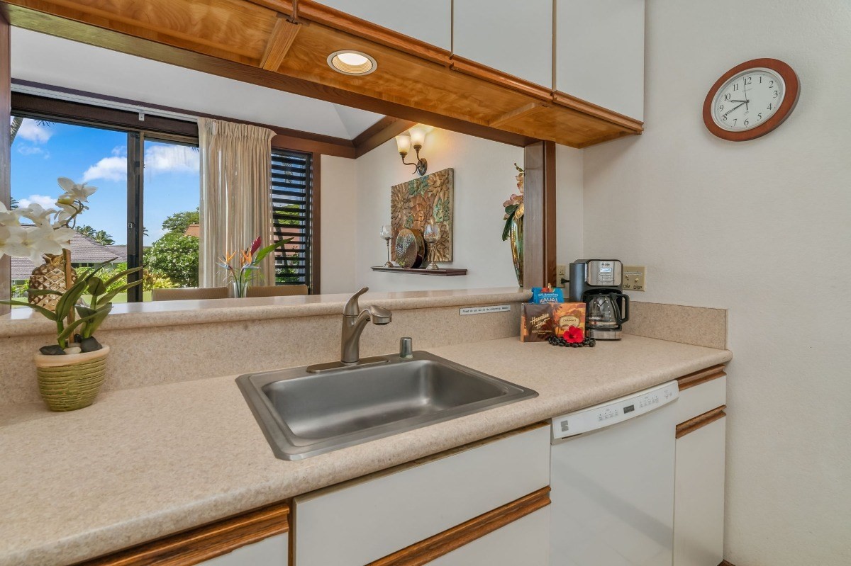 2253 Poipu Road, Unit 85 Koloa, HI 96756 - Photo 5 of 13 a kitchen with a sink and a clock on the wall