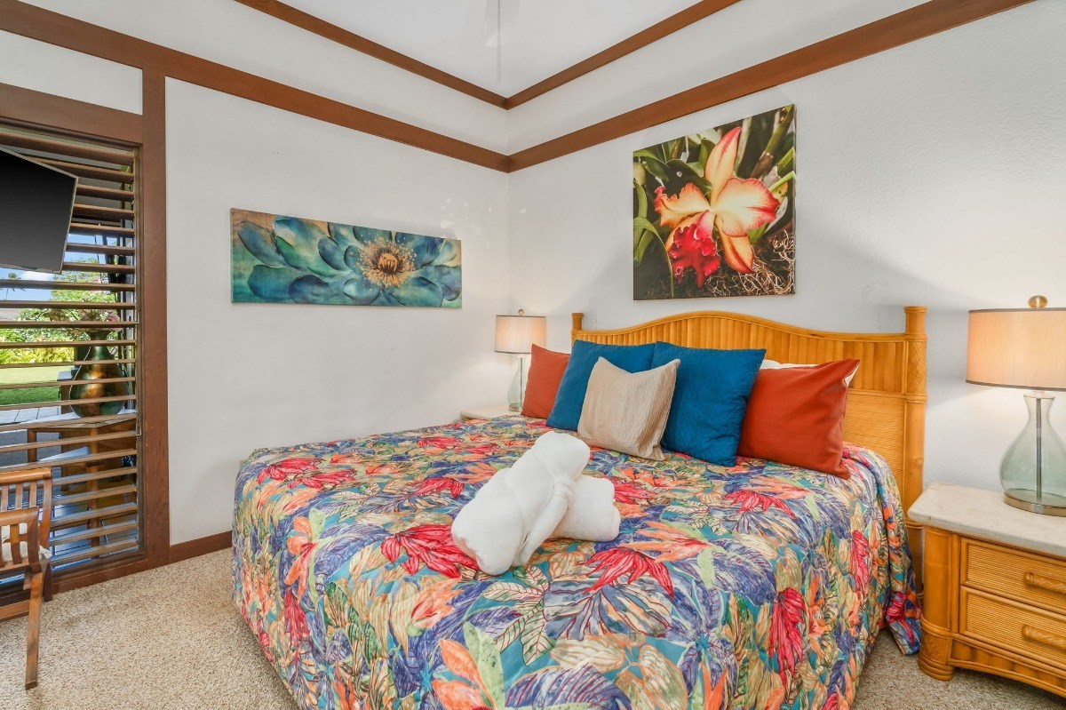 2253 Poipu Road, Unit 85 Koloa, HI 96756 - Photo 7 of 13 a bedroom with a bed a painting on the wall and a baby crib