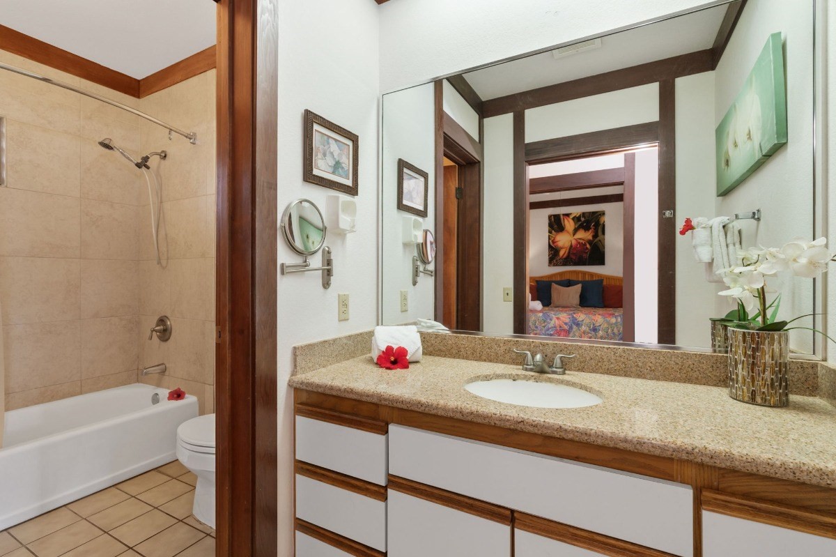 2253 Poipu Road, Unit 85 Koloa, HI 96756 - Photo 9 of 13 a bathroom with a granite countertop sink and a mirror