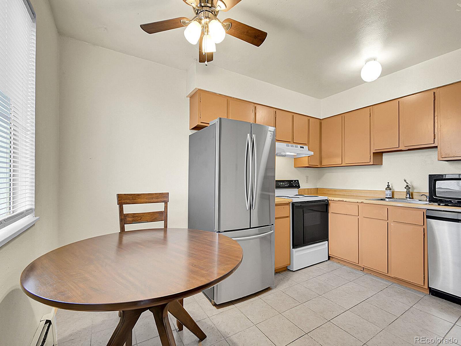 a kitchen with stainless steel appliances granite countertop a refrigerator a sink a stove with white cabinets