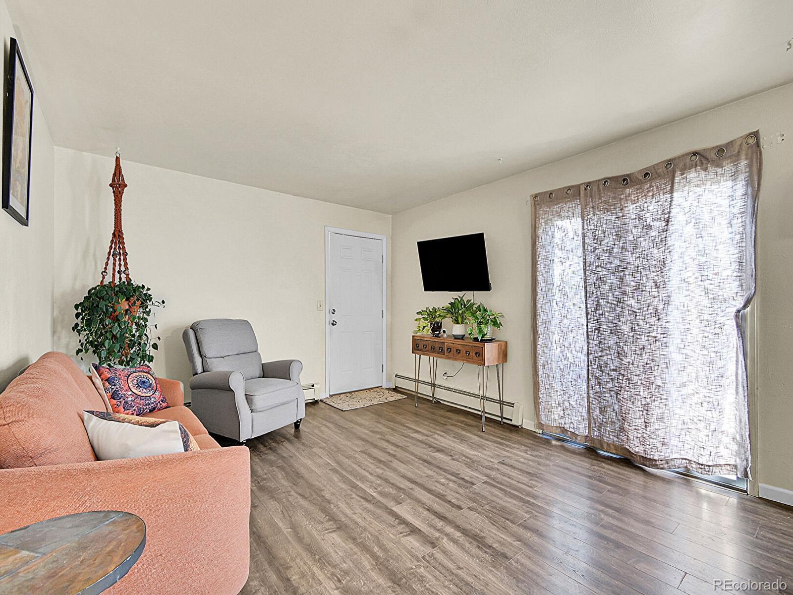 9340 West 49th Avenue, Unit 218 Wheat Ridge, CO 80033 - Photo 5 of 31 a living room with furniture and a flat screen tv