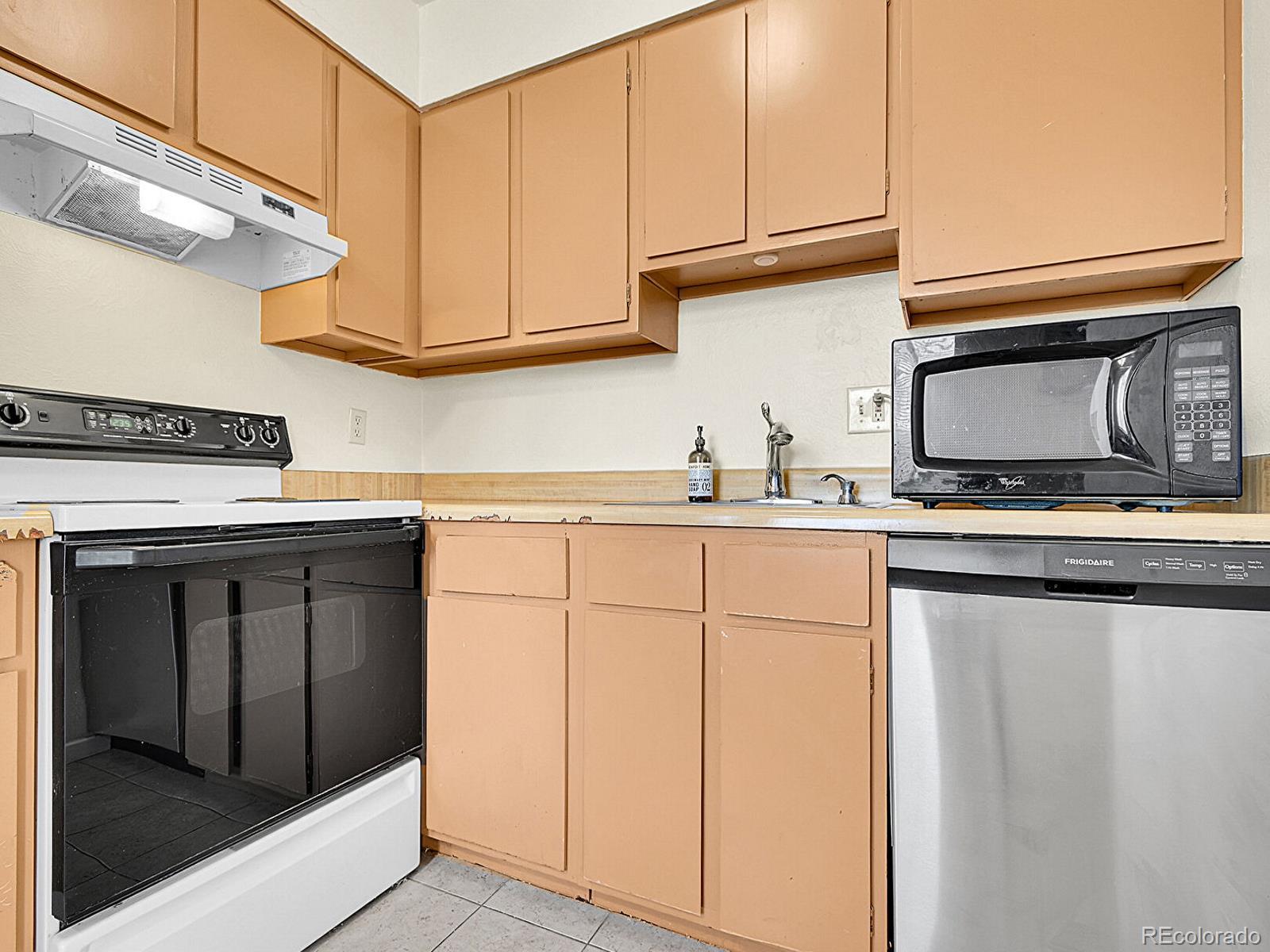 9340 West 49th Avenue, Unit 218 Wheat Ridge, CO 80033 - Photo 10 of 31 a kitchen with granite countertop white cabinets stainless steel appliances and sink