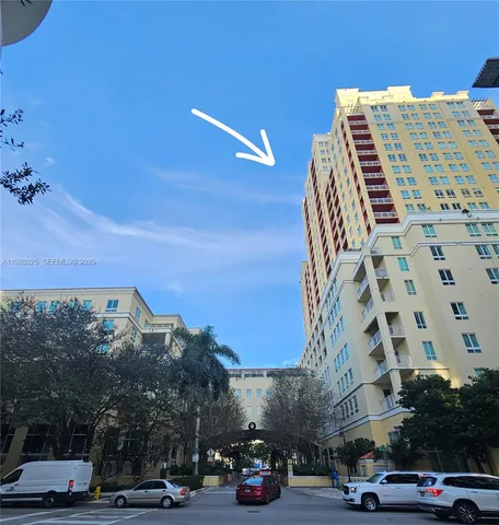 a front view of a building with parked cars