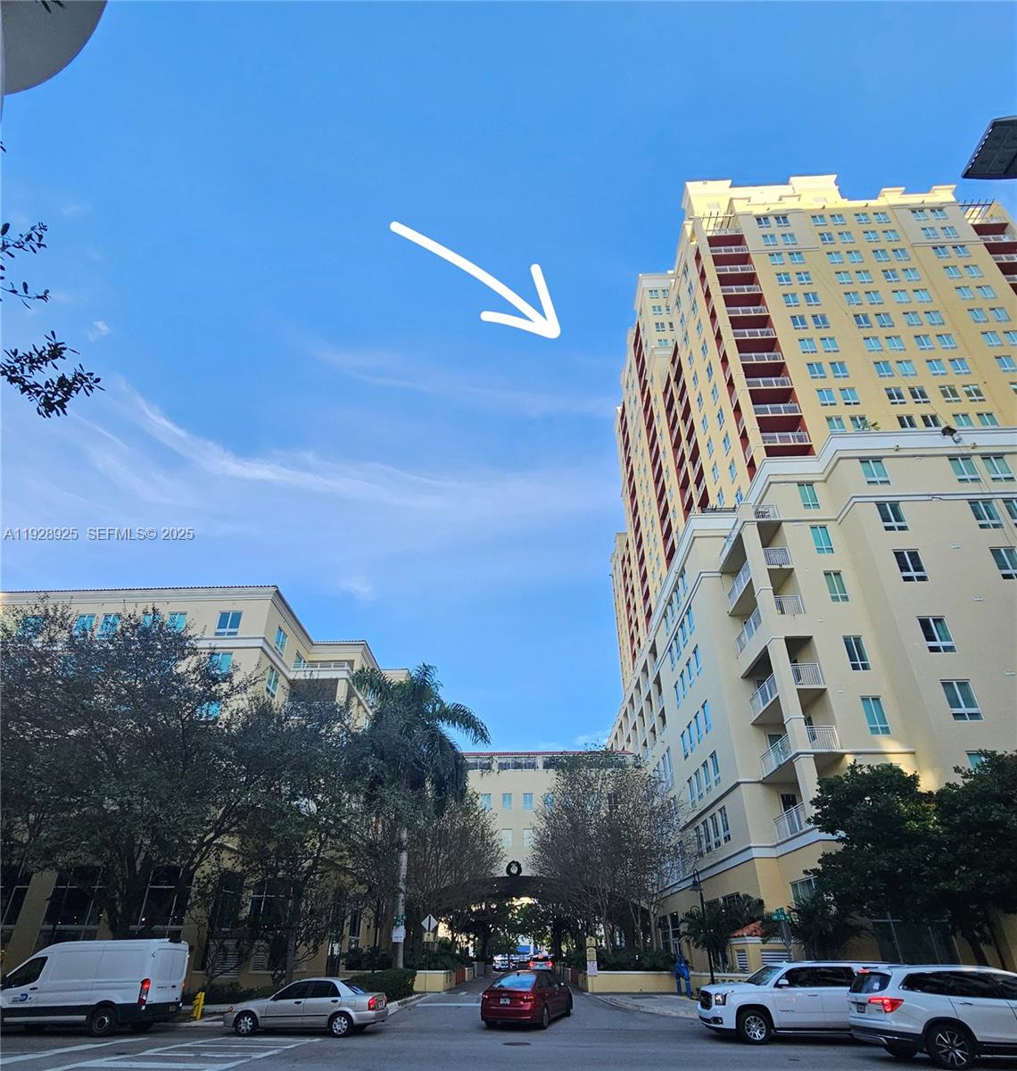 a front view of a building with parked cars