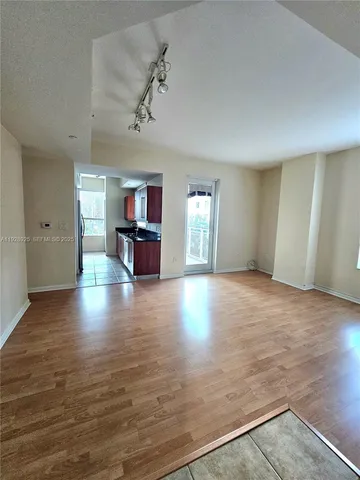 an empty room with windows and fireplace