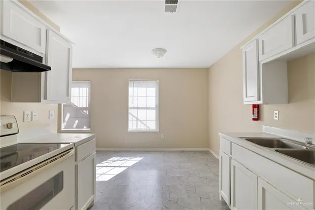 a kitchen with a sink stove and cabinets