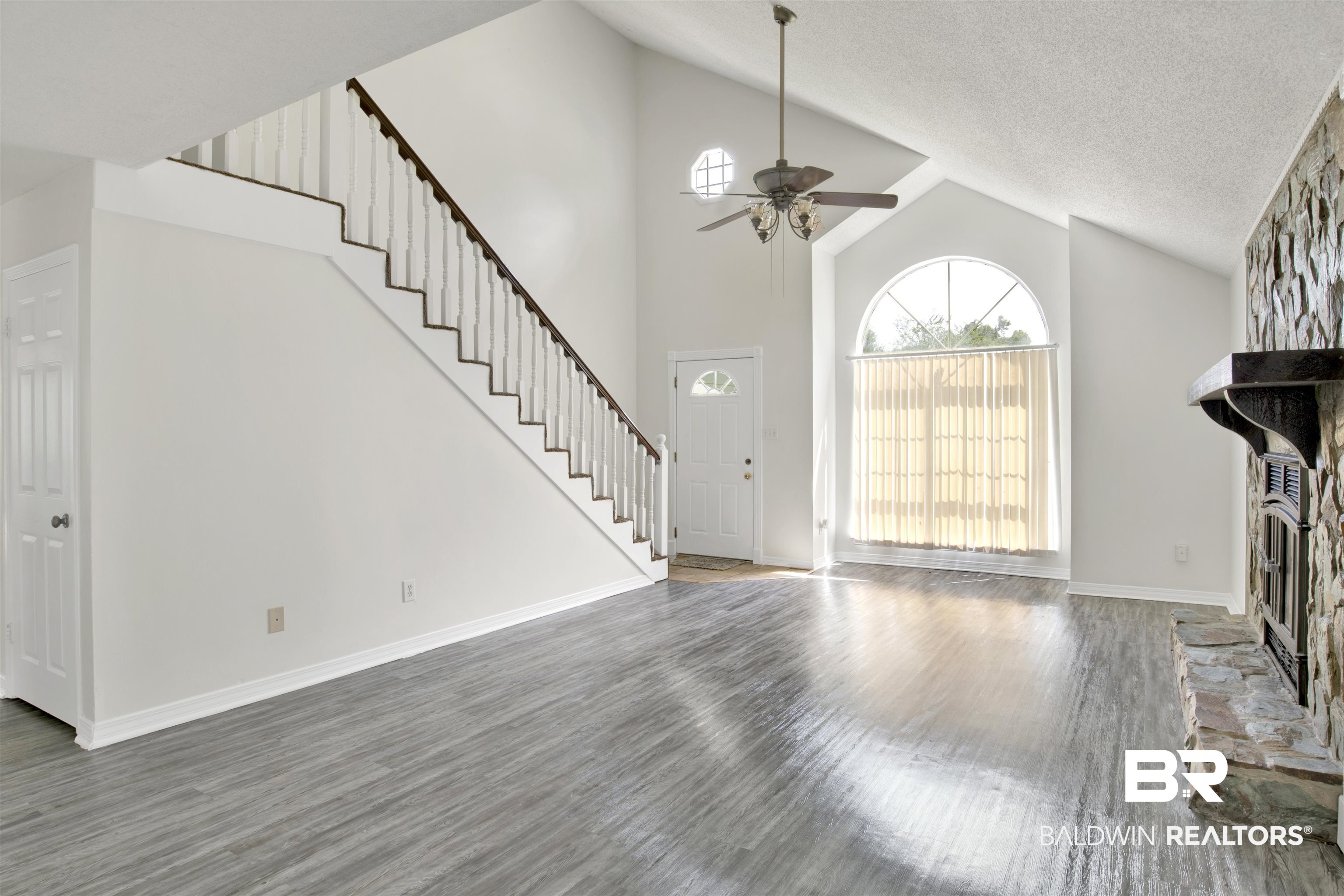 5480 Country Club Boulevard Theodore, AL 36582 - Photo 2 of 36 Unfurnished living room with a fireplace, high vaulted ceiling, dark wood-type flooring, ceiling fan, and a textured ceiling