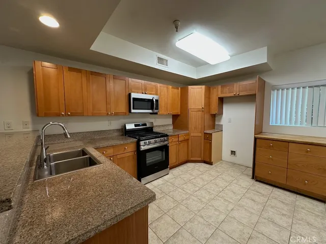 a kitchen with stainless steel appliances granite countertop a stove a sink and a microwave