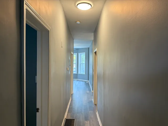 a view of a hallway with wooden floor