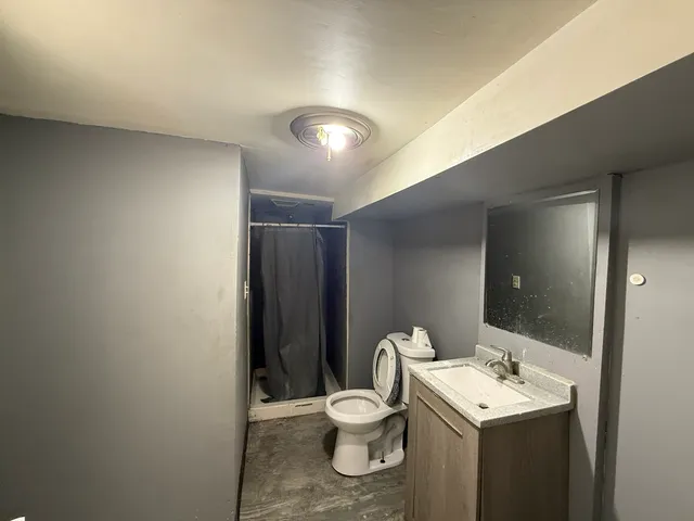 a bathroom with a toilet a sink and mirror