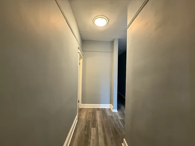 a view of a room with wooden floor and a window