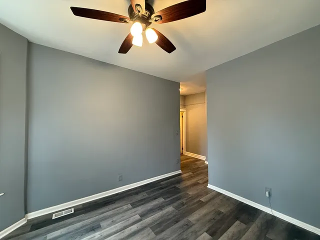 an empty room with a window and a fan