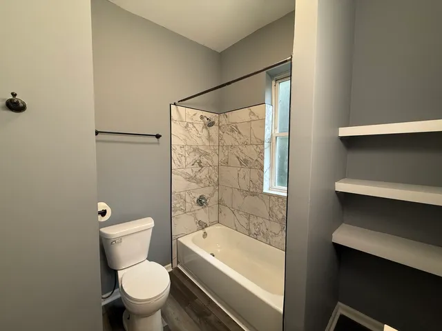 a white toilet sitting next to a bathroom sink and tub