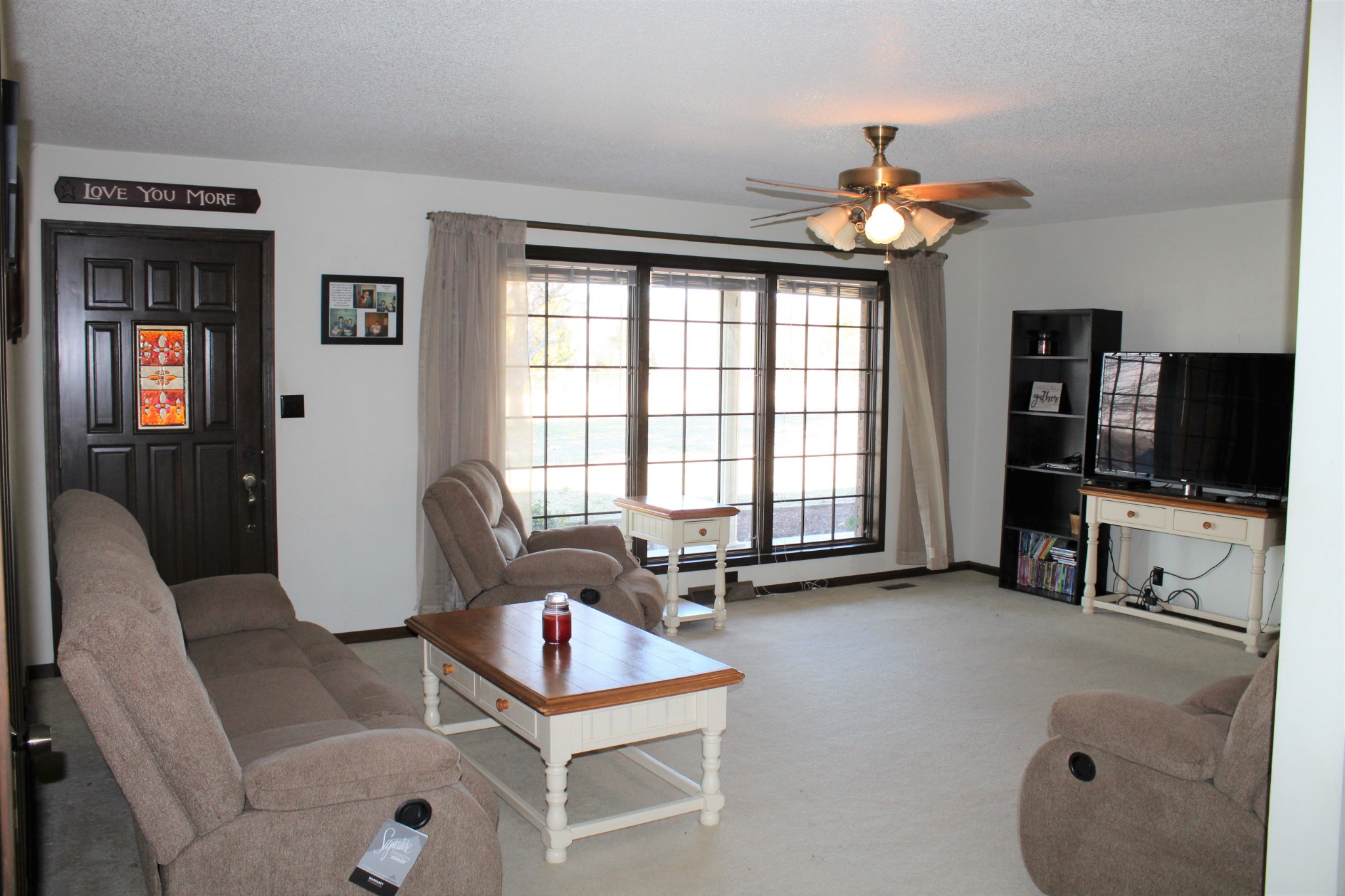 4165 Buckeye Road Cumberland City, TN 37050 - Photo 5 of 20 a living room with furniture a flat screen tv and a large window