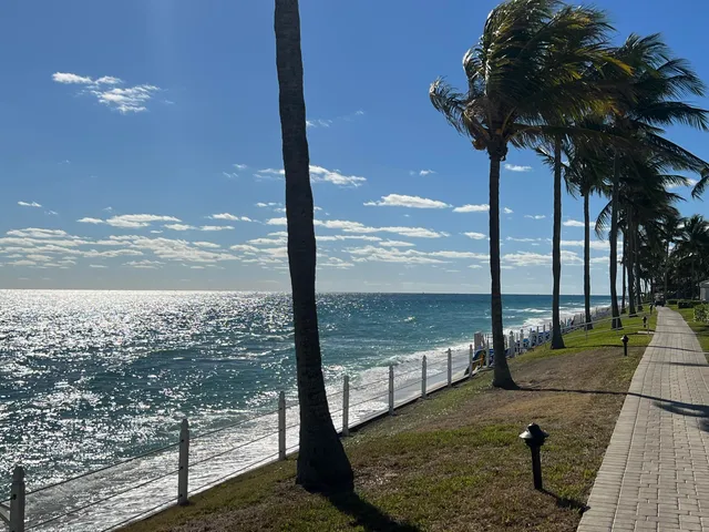 a living room with furniture a flat screen tv and a floor to ceiling window