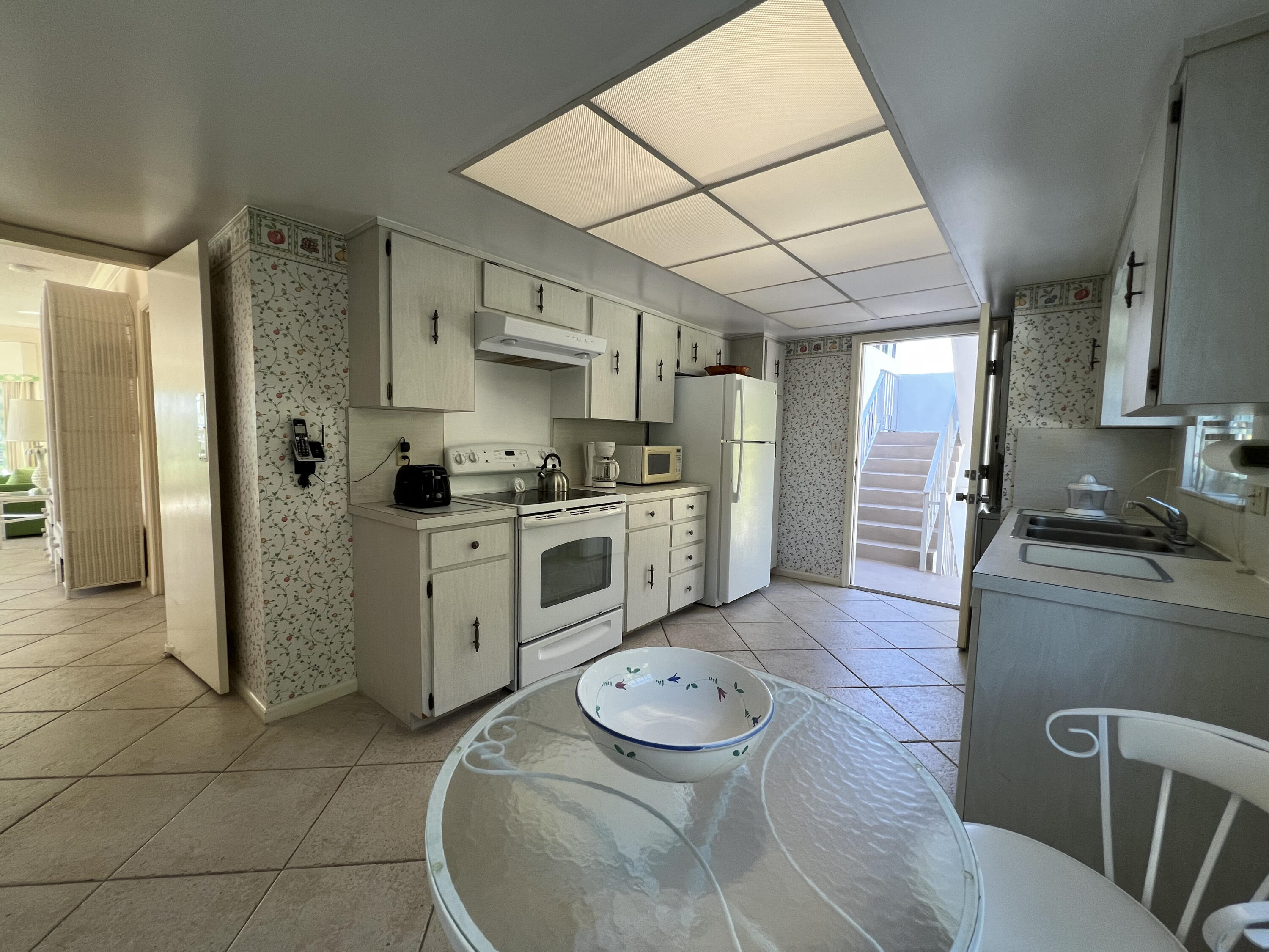 400 South Ocean Boulevard, Unit 103A Lake Worth, FL 33462 - Photo 9 of 12 a kitchen with stainless steel appliances granite countertop a stove a refrigerator and a cabinets