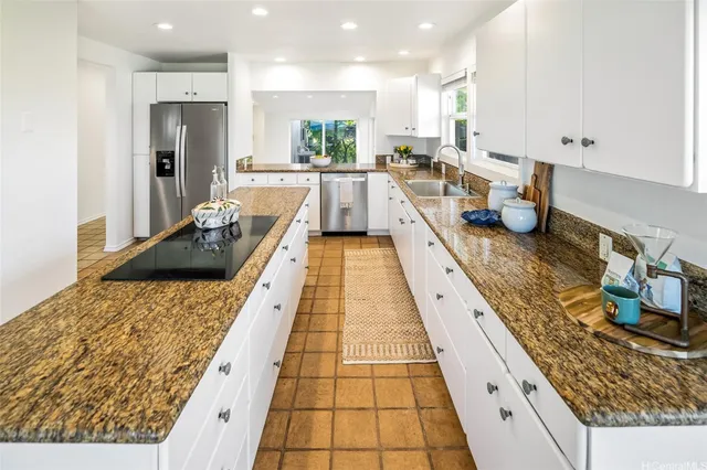 a large kitchen with stainless steel appliances a stove a sink and a granite counter tops