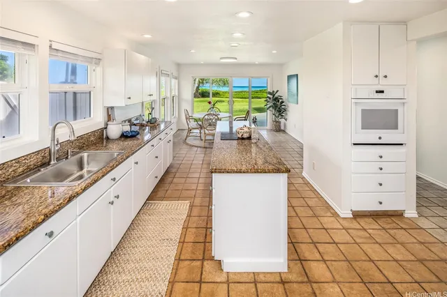 a kitchen with kitchen island granite countertop a sink and a counter top space