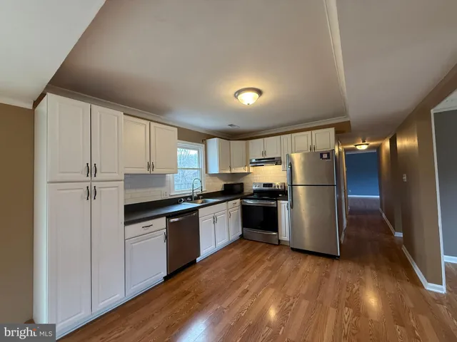 a kitchen with a refrigerator and a stove top oven