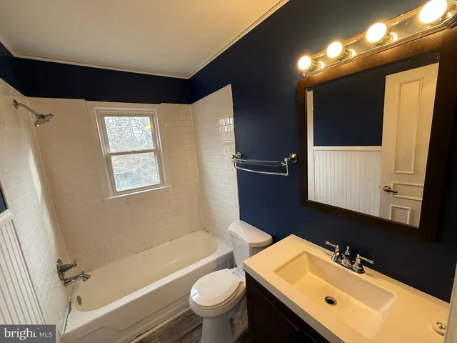 a bathroom with a sink toilet double vanity and bathtub