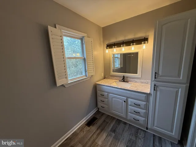 a bathroom with a sink a mirror and a window
