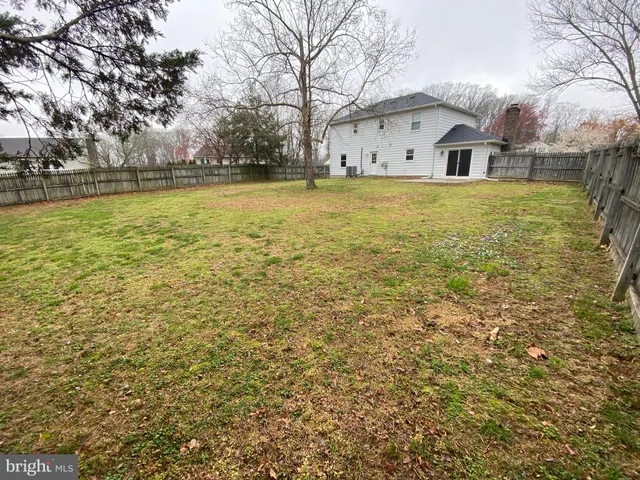 a view of a large pool with lawn chairs under an umbrella