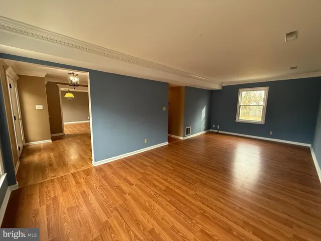 a view of empty room with window and wooden floor