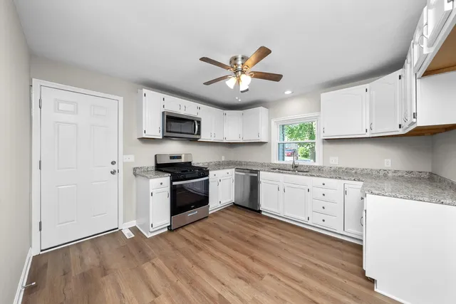a kitchen with stainless steel appliances granite countertop a stove a sink and a refrigerator