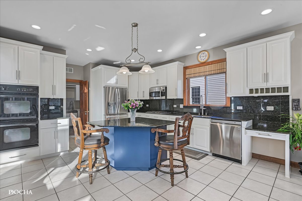 1107 Tuthill Road Naperville, IL 60563 - Photo 11 of 59 a kitchen with stainless steel appliances granite countertop a stove a sink a oven a dining table and chairs