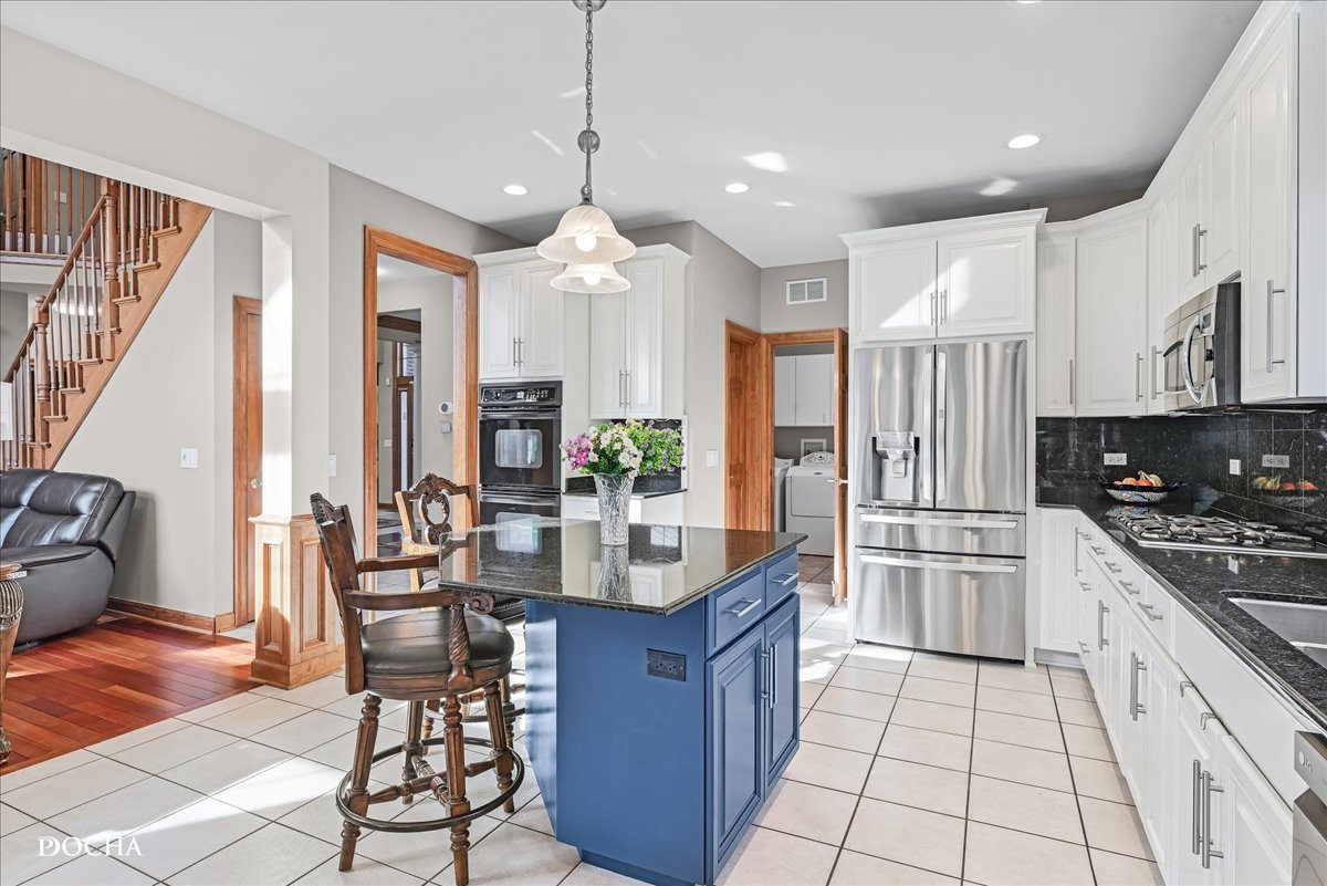 1107 Tuthill Road Naperville, IL 60563 - Photo 10 of 59 a kitchen with stainless steel appliances granite countertop a stove top oven a refrigerator a sink and white cabinets