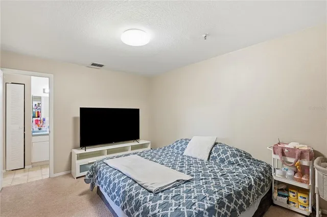 a bedroom with a bed and a flat screen tv