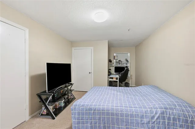 a bedroom with a bed and flat screen tv