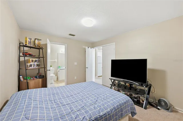 a bedroom with a bed and a flat screen tv