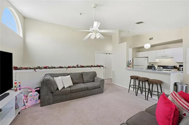 a living room with furniture kitchen view and a chandelier