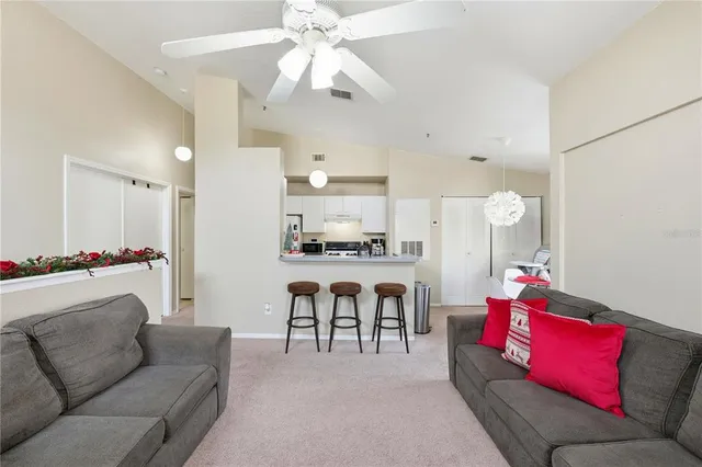 a living room with furniture and kitchen view